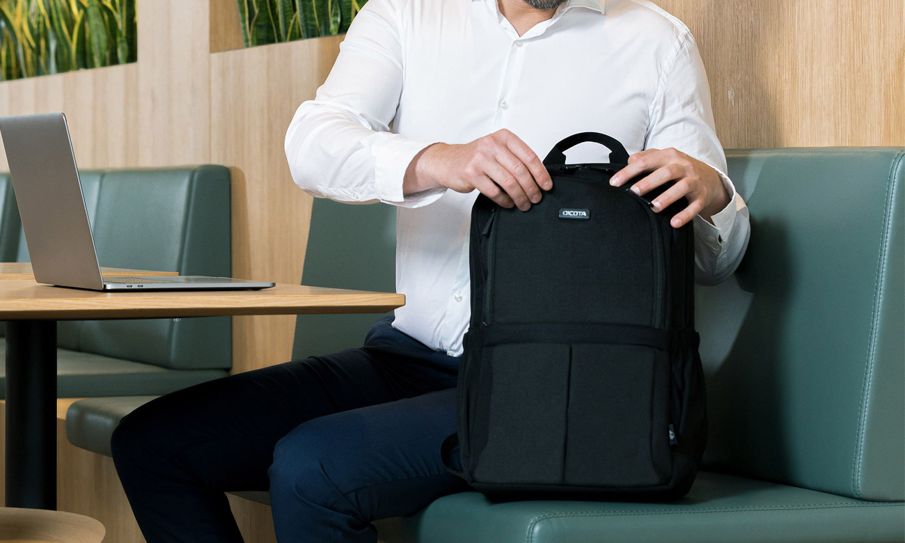 Mann öffnet Dicota Eco SCALE Rucksack